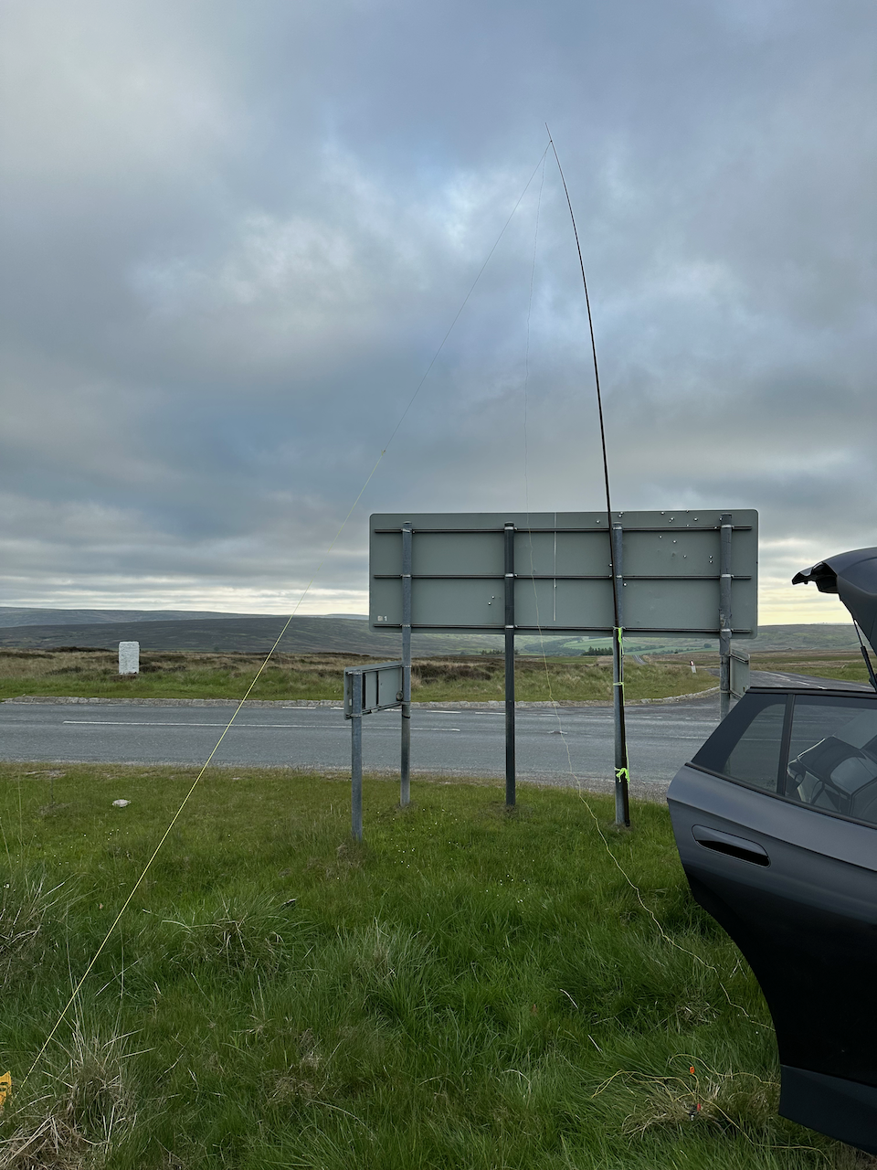 An end fed antenna mounted on a portable mast strapped to a road sign An end fed antenna mounted on a portable mast strapped to a road sign