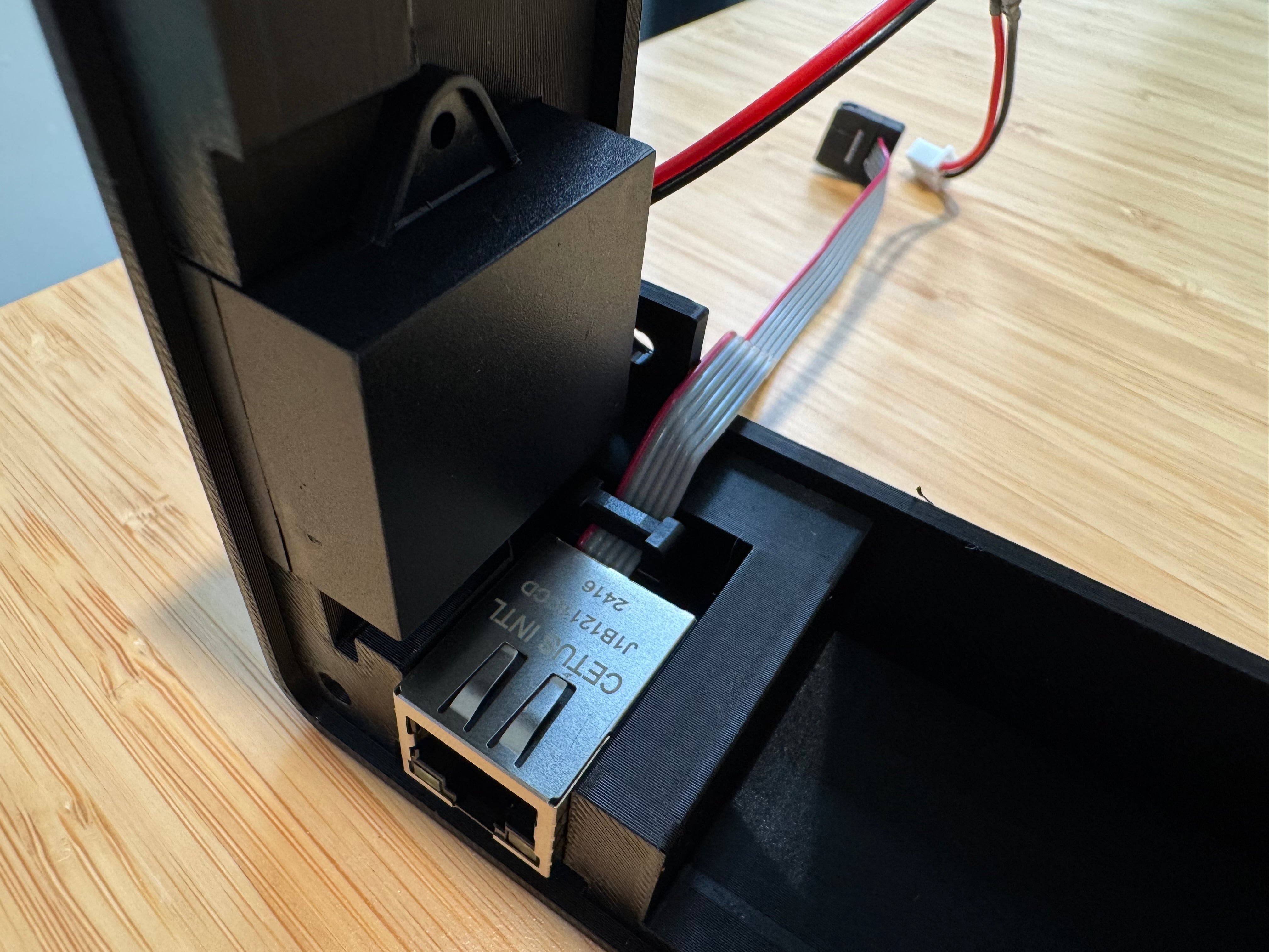 The Ethernet port seen from outside the case, with its ribbon cable running into the case