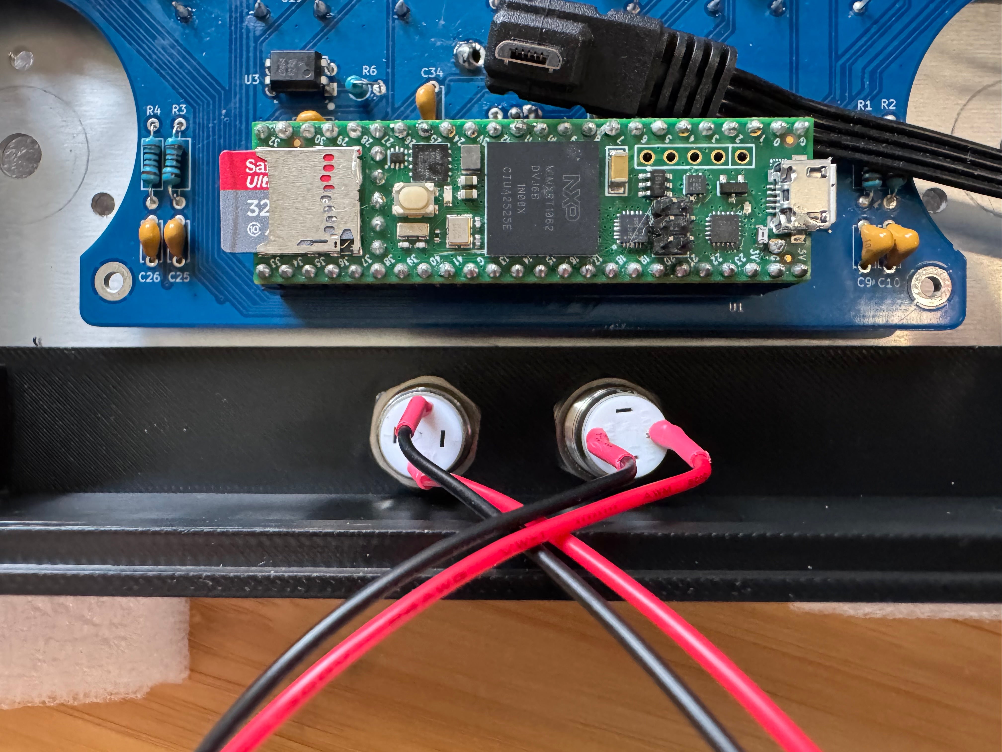 The two front buttons fitted through the case below the Teensy board, with their red and black wires crossing