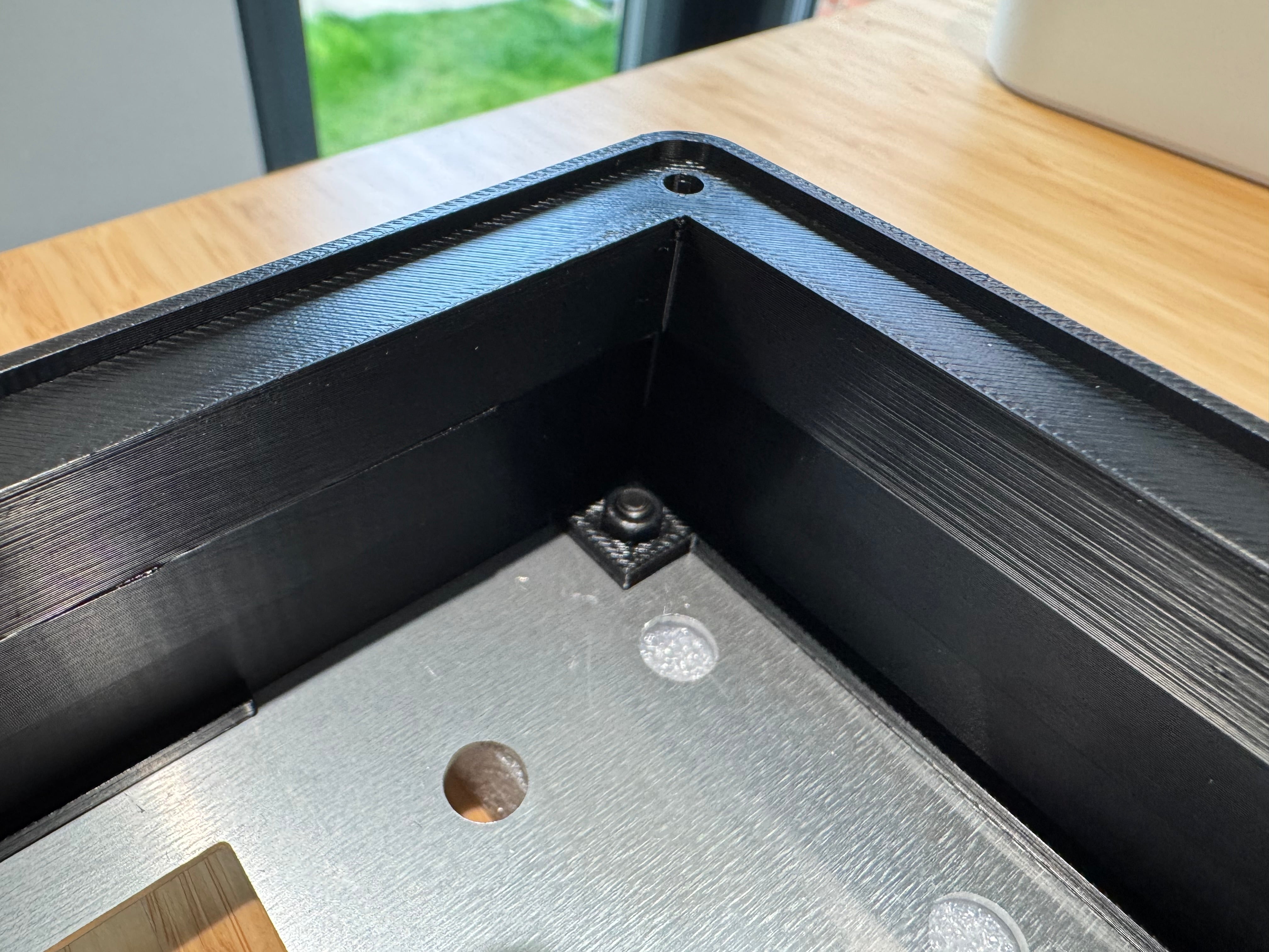 Inside a corner of the case, an M4 nut fitted to the back of a front panel bolt