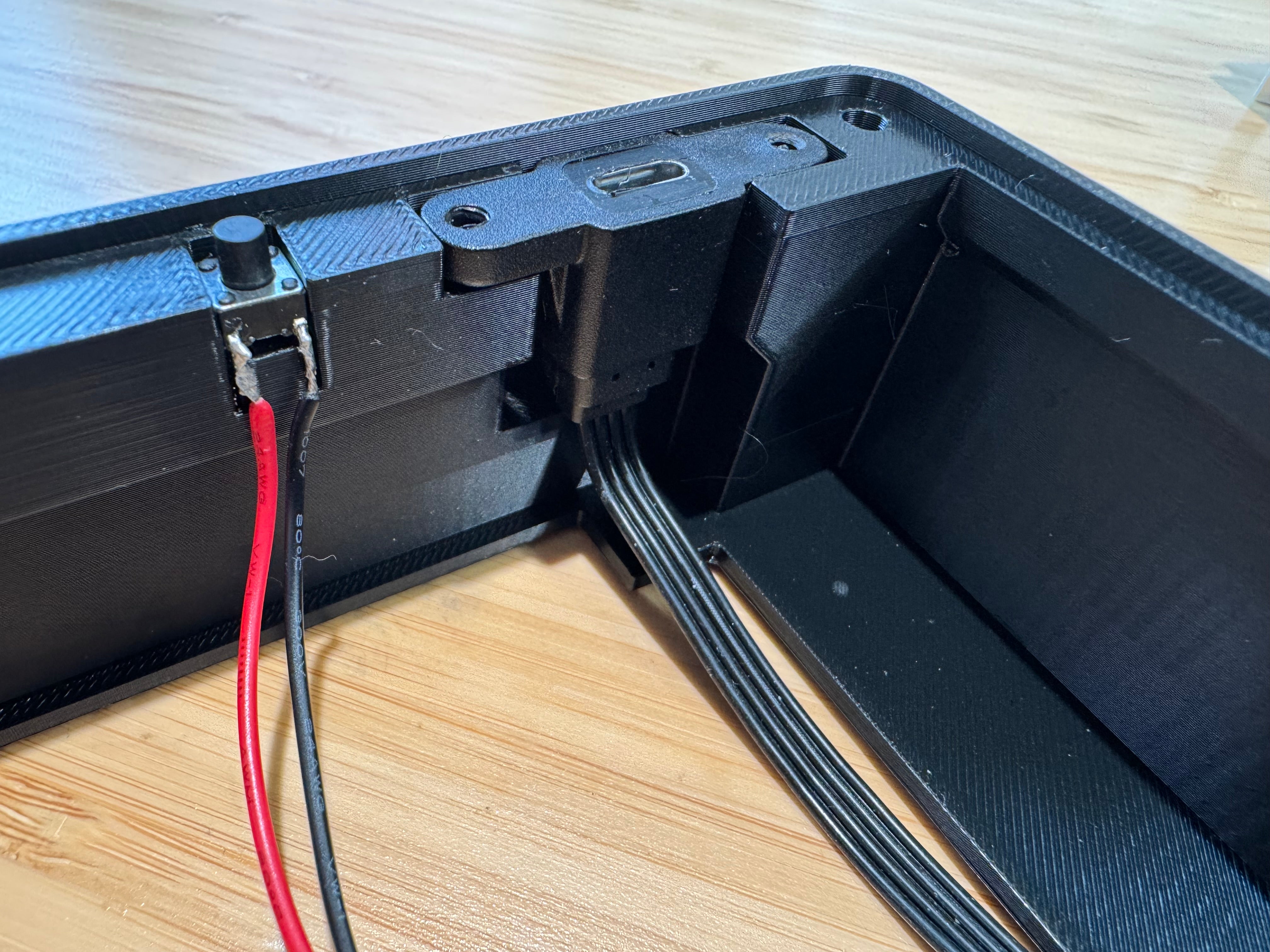 Inside the case, the program button next to the USB port mounted in its printed holder, with a ribbon cable running from it